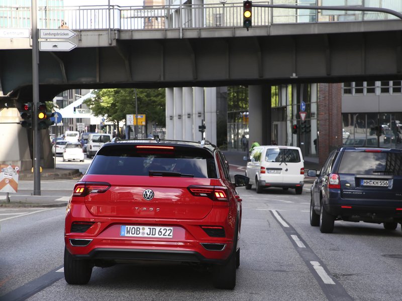 rotes Auto, dass unter einer Brücke in der Stadt durch fährt